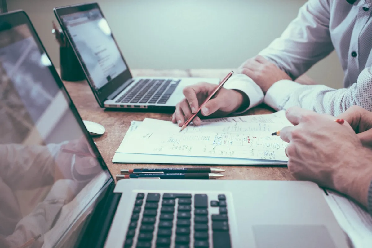 Two people reviewing financial documents together at a desk, illustrating beneficiary communication and trust accounting review